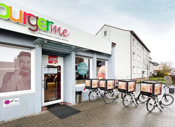 Außenansicht von burgerme-Filiale mit Lieferfahrrädern vor dem Geschäft. Frisch gemachte und pünktlich gelieferte Burger.