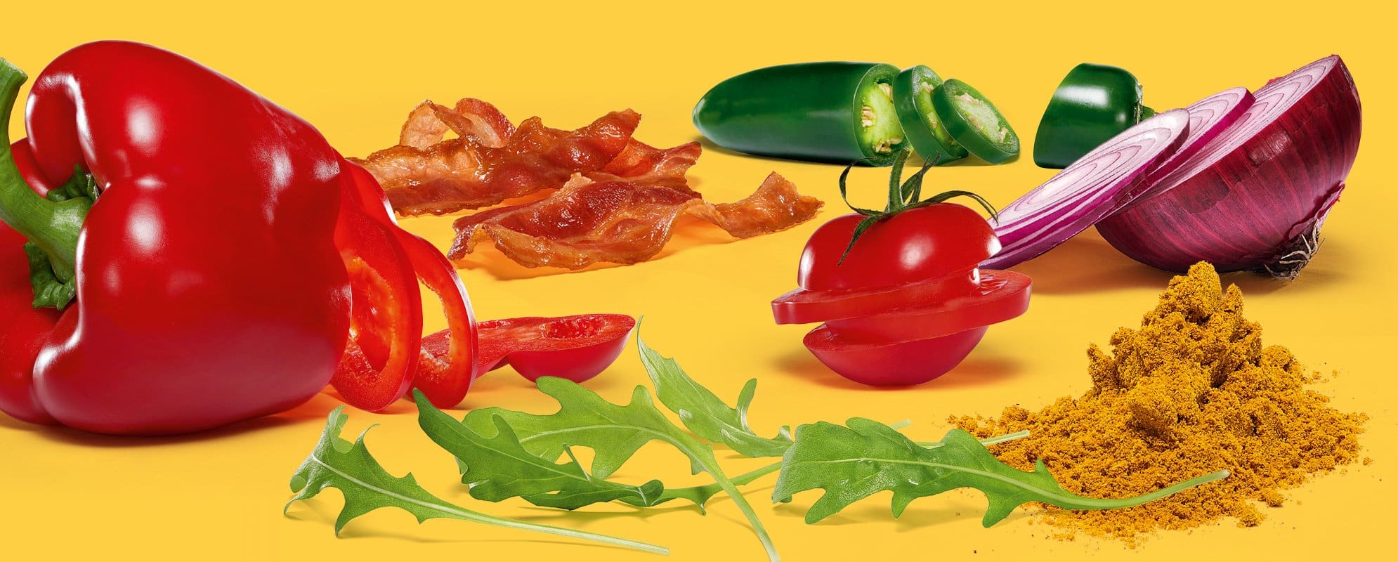 Frische Zutaten bei burgerme: Paprika, Rucola, Tomate, Zwiebel, Bacon, Jalapeños und Gewürze auf gelbem Hintergrund.