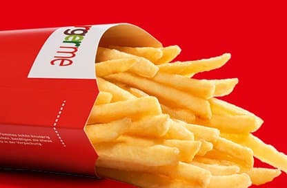 Knusprige Pommes Frites in einer Burgerme-Verpackung vor einem roten Hintergrund. Perfekte Beilage für Burger.